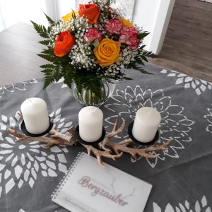 Dekorierter Esstisch mit Blumen, Kerzen und Gästebuch