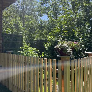 Eingezäunte Terrasse mit Gartenblick und Holzfassade