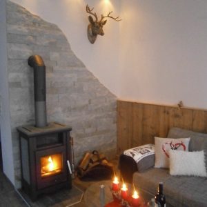 Gemütlicher Wohnbereich mit Couch und brennendem Kamin